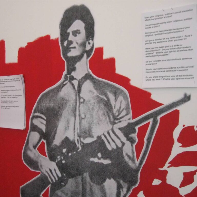 Црно-бели исечак особе која држи пушку, постављен на црвено-белој позадини. Штампани листови са откуцаним питањима евоцирају уметност и активизам, наговештавајући посвећеност Контекст колектива солидарности кроз уметност.